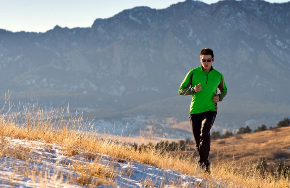 Runner With Green Top On A Mountain